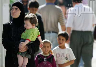 سيدة سورية مع أطفالها تتجه نحو مخيمات اللاجئين في تركيا